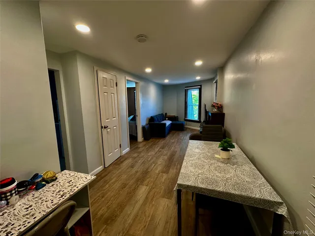 a open kitchen with kitchen island a refrigerator stove and wooden floor