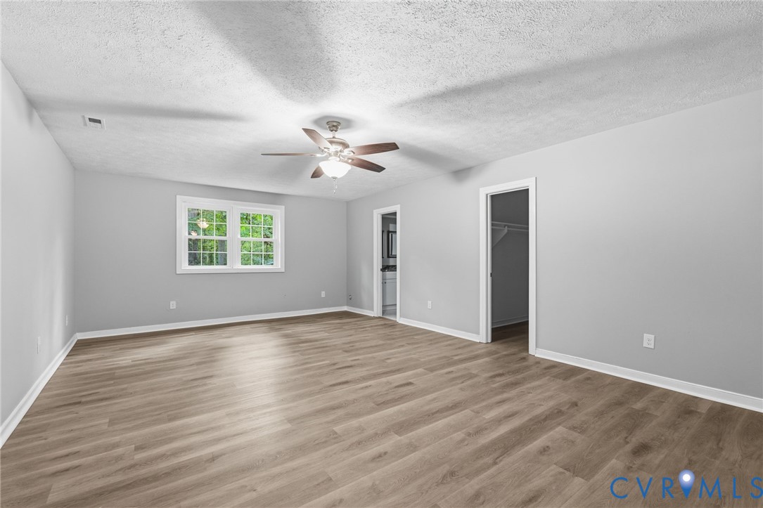 10731 Spring Run Road Chesterfield, VA 23832 - Photo 26 of 33 an empty room with wooden floor chandelier fan and windows