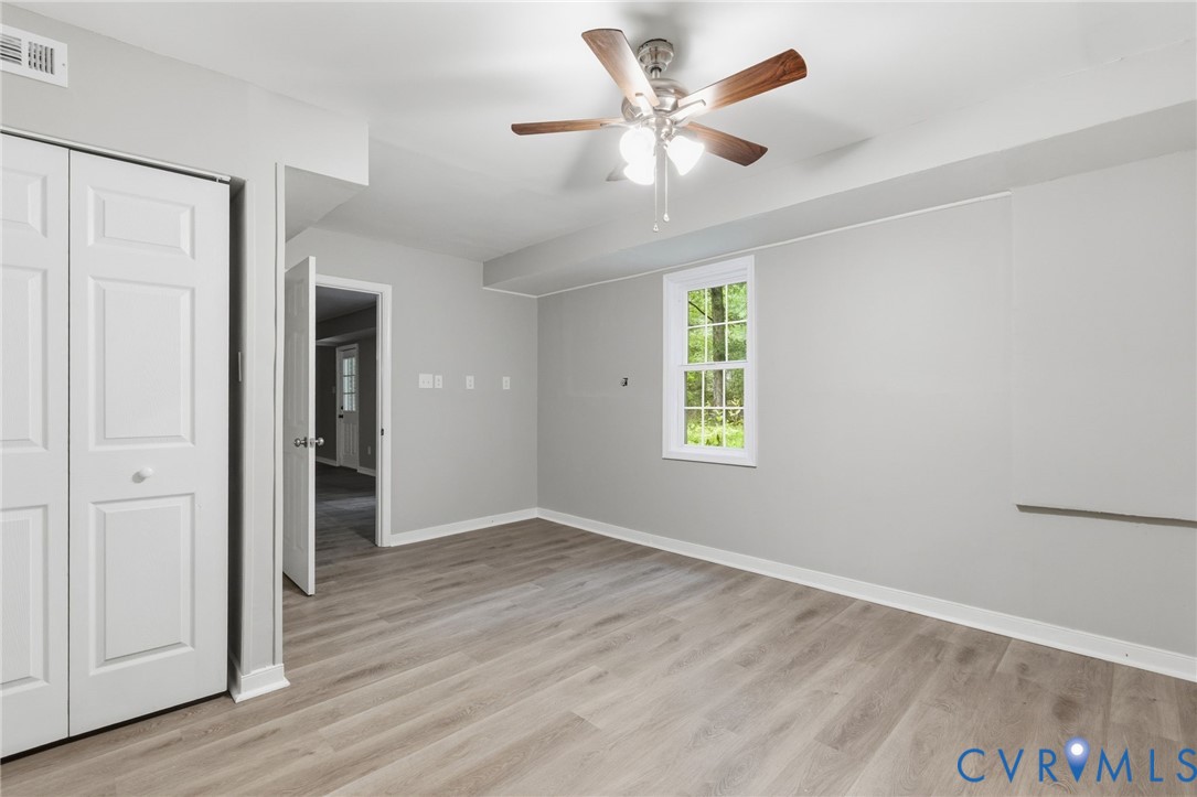 10731 Spring Run Road Chesterfield, VA 23832 - Photo 30 of 33 an empty room with wooden floor ceiling fan and windows