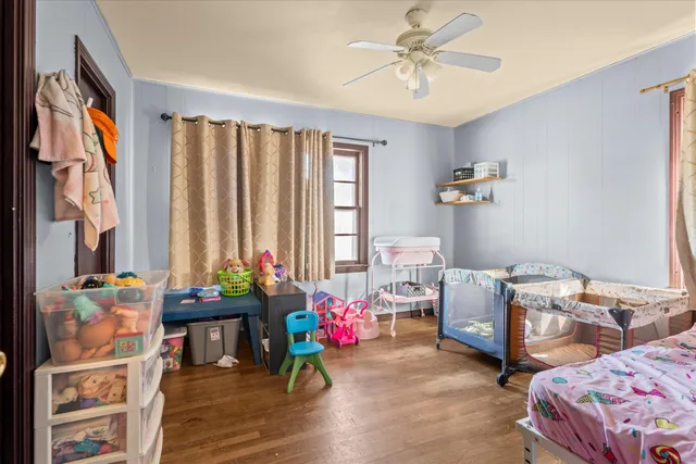 a bedroom with a bed a dresser and book shelf