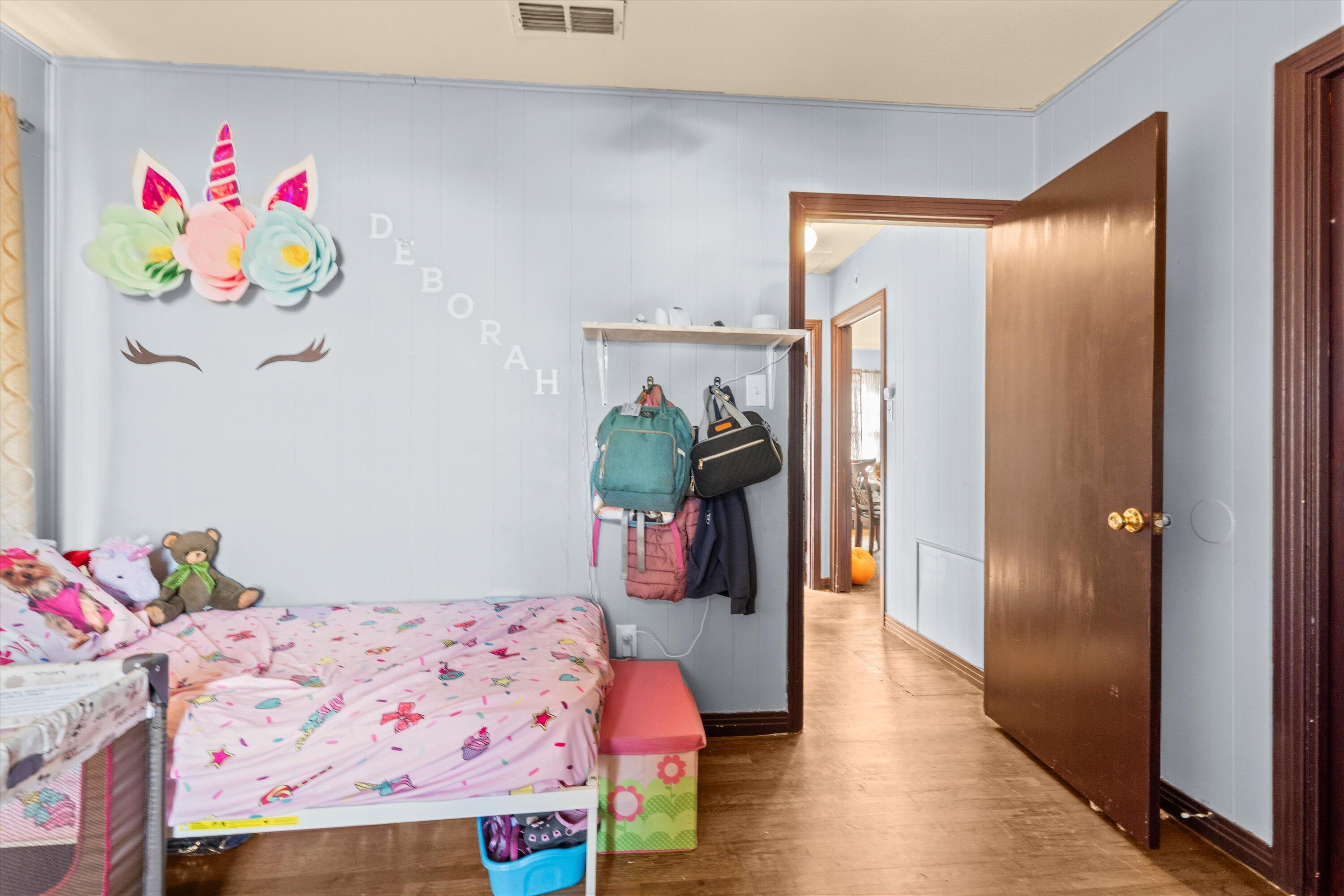 1915 37th Street Lubbock, TX 79412 - Photo 15 of 20 a bedroom with a bed a dresser and book shelf