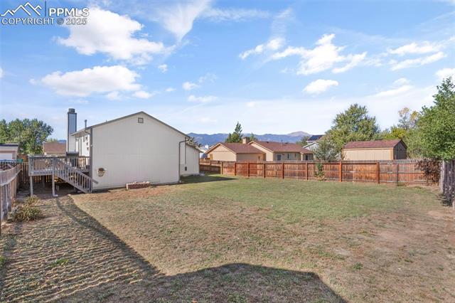 4469 Fenton Road Colorado Springs, CO 80916 - Photo 31 of 38 Fenced backyard featuring a wooden deck, and stairway