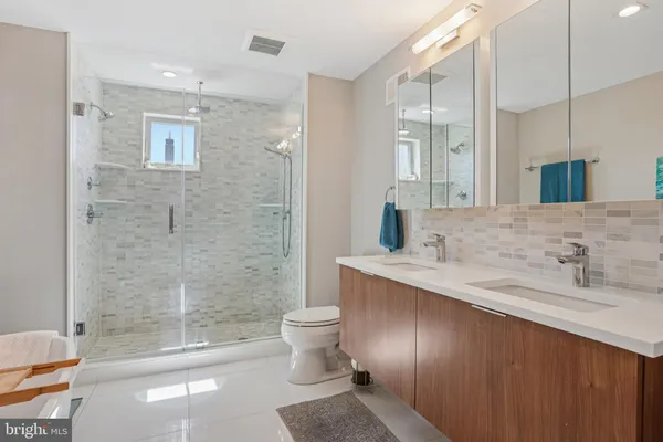 a bathroom with a sink a toilet and shower