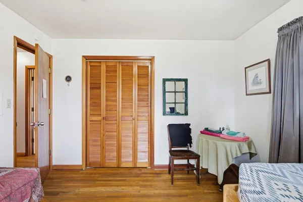 a bedroom with a bed and wooden floor