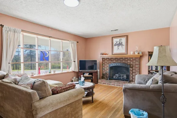 a living room with furniture a large window and a fireplace