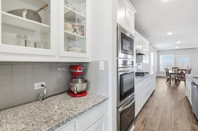 a kitchen with stainless steel appliances granite countertop a refrigerator and a stove
