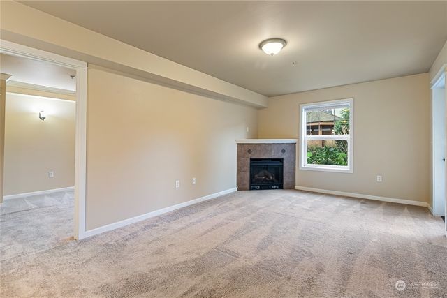 an empty room with a fireplace and window