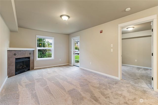 an empty room with windows and a fireplace