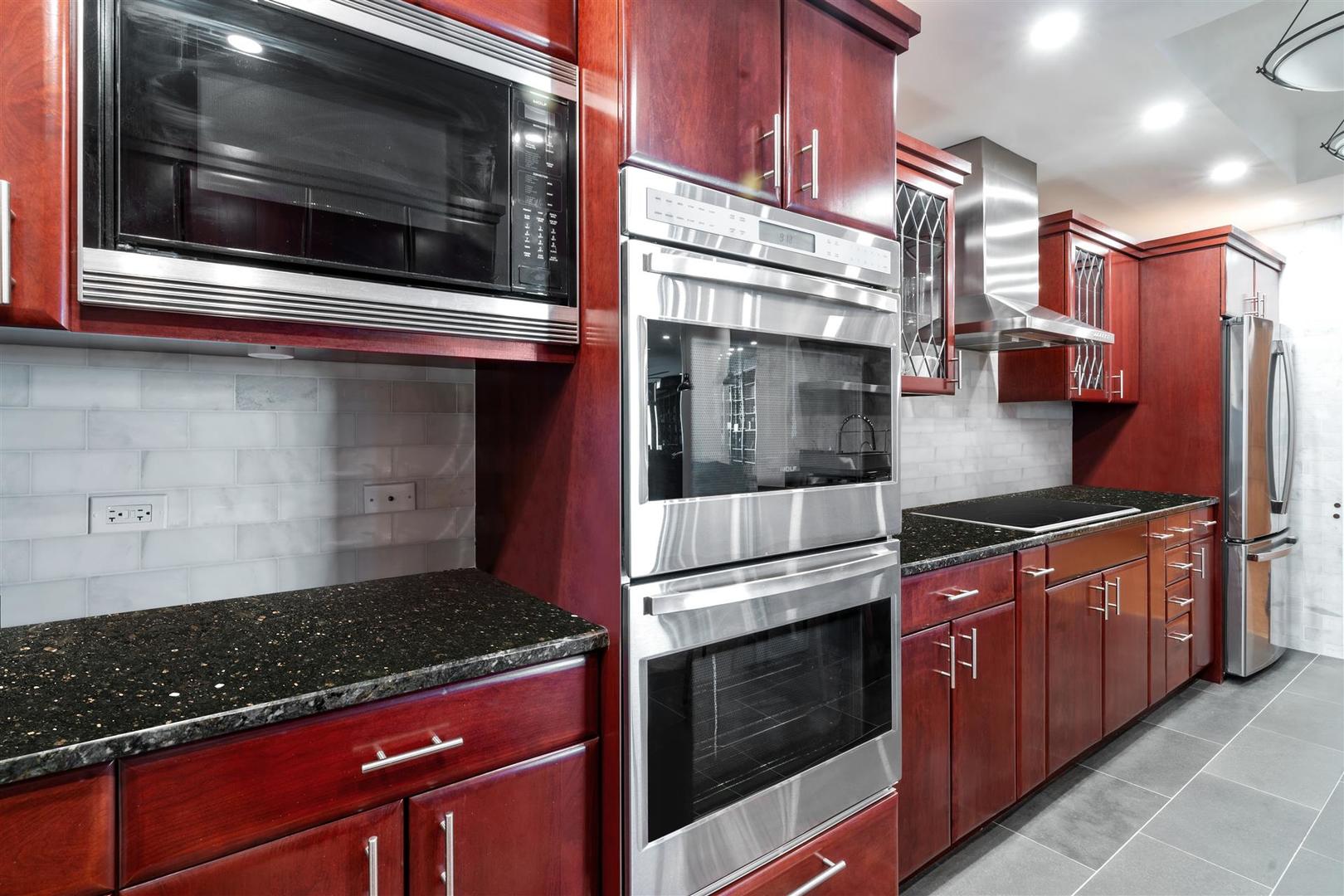 680 North Lake Shore Drive, Unit 1103 Chicago, IL 60611 - Photo 4 of 28 a kitchen with stainless steel appliances granite countertop a stove and a microwave