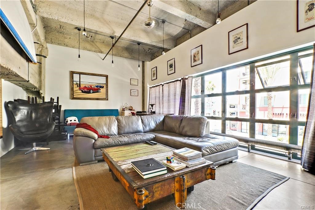 100 West 5th Street, Unit 2G Long Beach, CA 90802 - Photo 6 of 17 a living room with furniture a flat screen tv and a floor to ceiling window