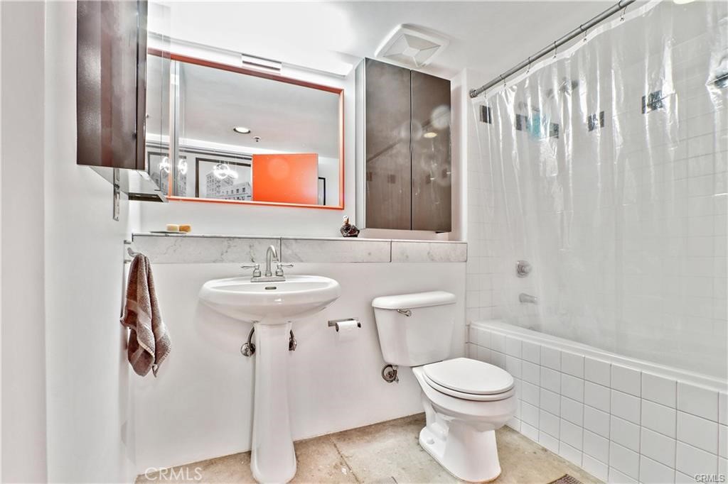 100 West 5th Street, Unit 2G Long Beach, CA 90802 - Photo 9 of 17 a bathroom with a toilet sink and mirror