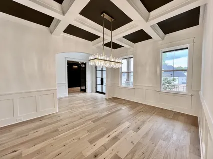 a dining room with furniture a chandelier and wooden floor