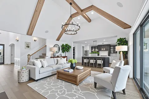 a living room with furniture a fireplace and a chandelier
