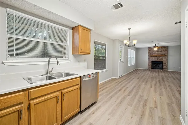 a kitchen with stainless steel appliances granite countertop a sink cabinets and wooden floor