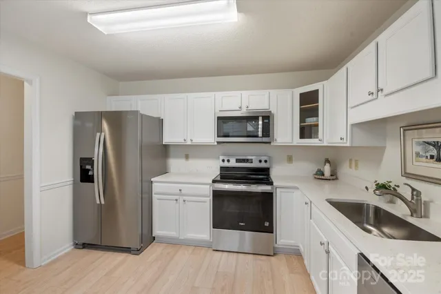 a kitchen with granite countertop a refrigerator stove and sink
