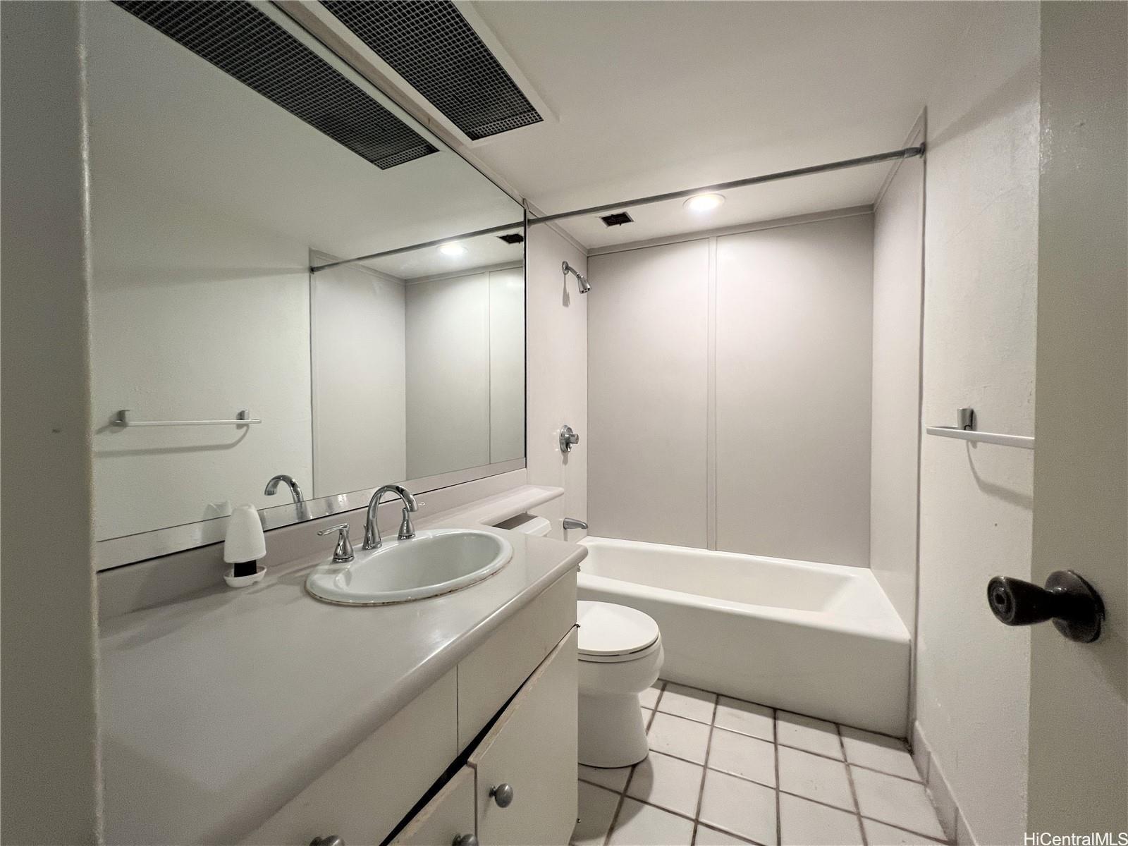 1860 Ala Moana Boulevard, Unit 902B Honolulu, HI 96815 - Photo 14 of 15 a bathroom with a granite countertop sink a toilet and shower