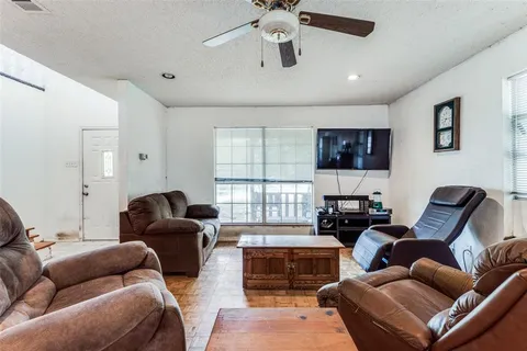 a living room with furniture a ceiling fan and a window