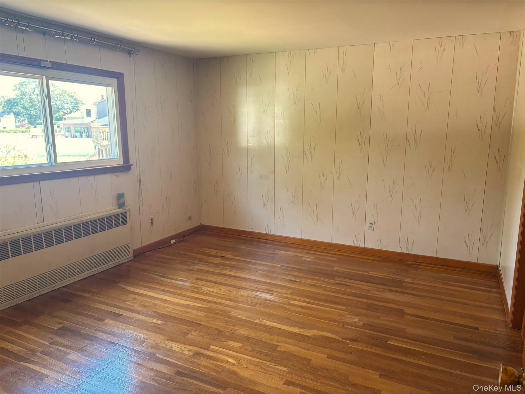 10 13th Avenue West Babylon, NY 11704 - Photo 11 of 33 a view of an empty room with wooden floor and a window