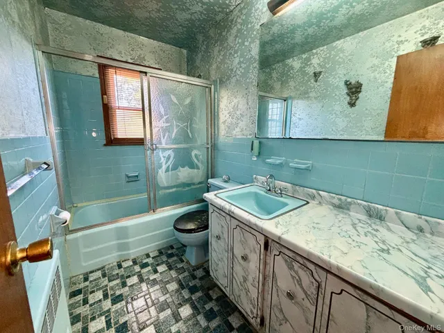 a bathroom with a granite countertop sink a toilet and bathtub