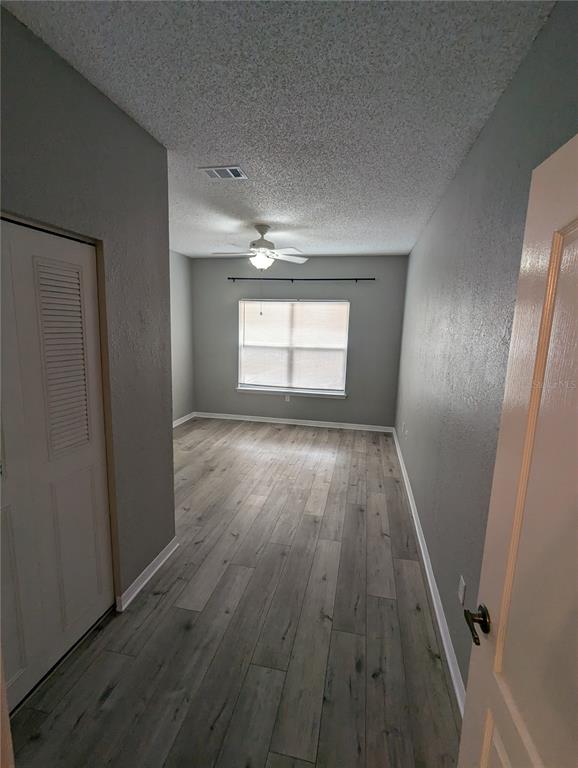 903 Normandy Trace Road Tampa, FL 33602 - Photo 12 of 14 an empty room with wooden floor and windows