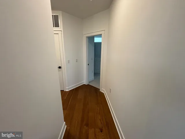 a view of a hallway with wooden floor