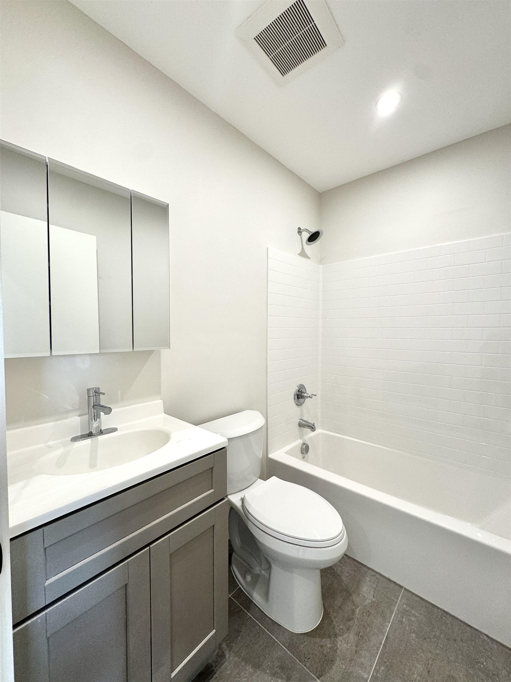 103 Bostwick Avenue, Unit 2C Jersey City, NJ 07305 - Photo 5 of 11 a bathroom with a toilet a sink a mirror and a bathtub