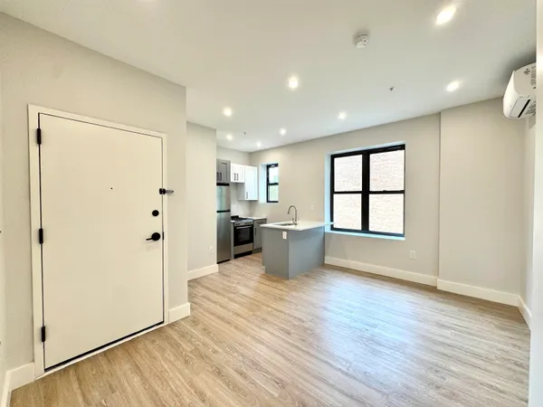 a view of a kitchen with a refrigerator and wooden floor