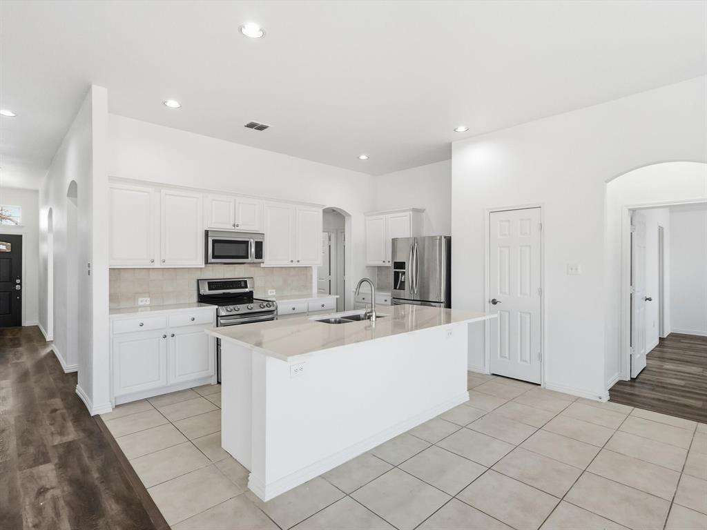 424 Shady Shore Lane Crowley, TX 76036 - Photo 14 of 40 a kitchen with stainless steel appliances a sink a stove a refrigerator cabinets and a window