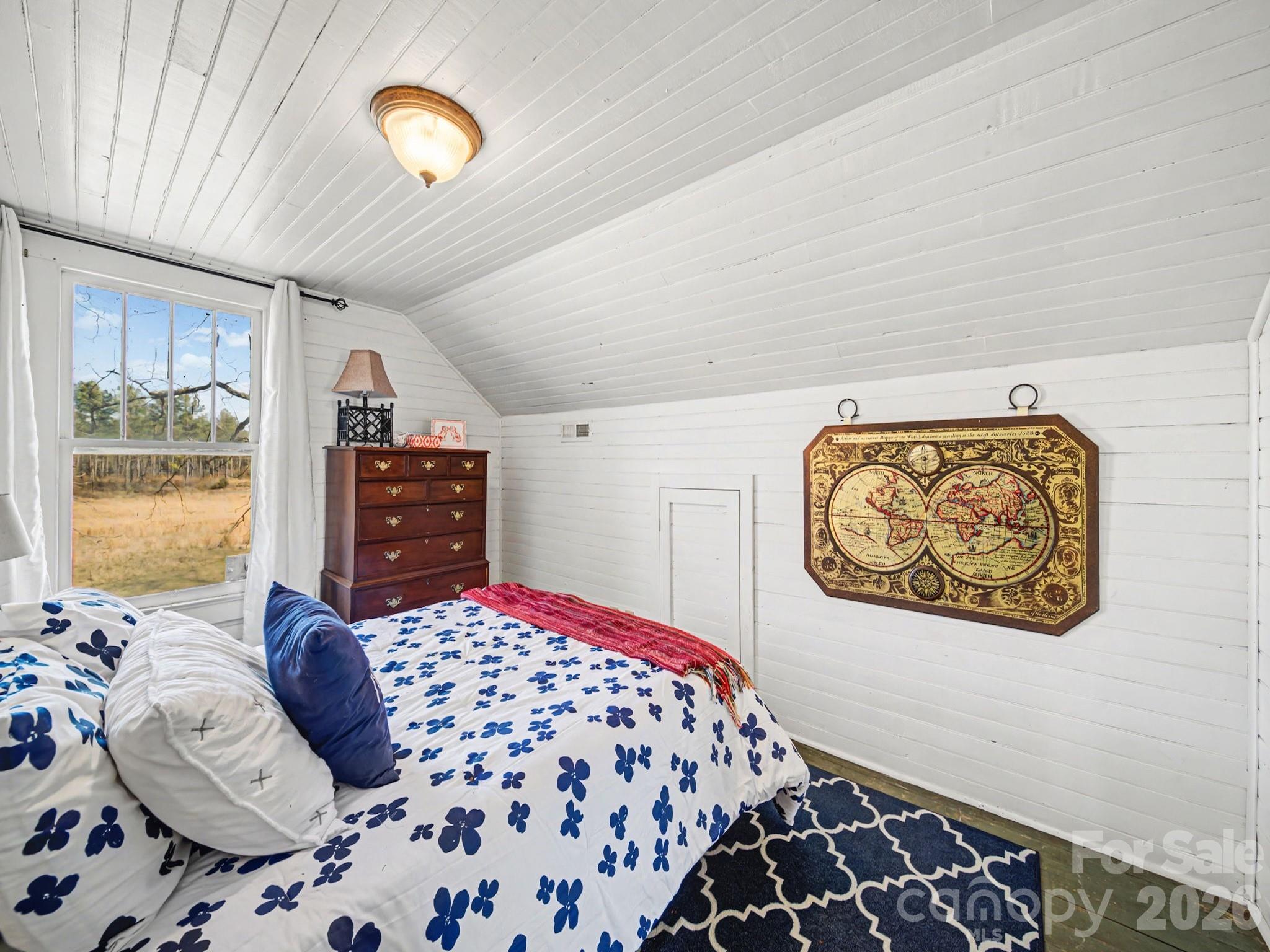 1347 Newsom Road Denton, NC 27239 - Photo 39 of 47 a bedroom with a large bed and a chandelier