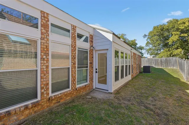 a view of backyard with large trees and wooden fence