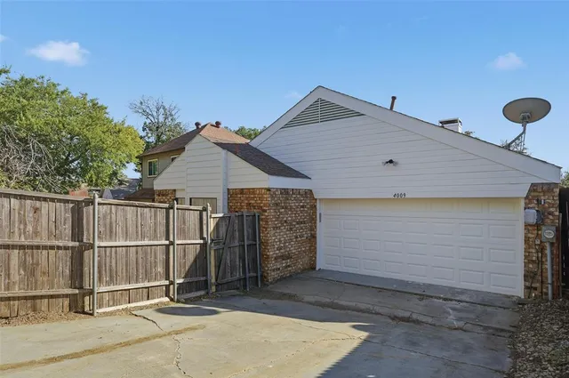 a side view of a house with wooden fence
