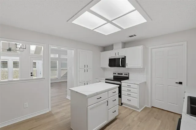 a kitchen with stainless steel appliances a stove microwave and refrigerator