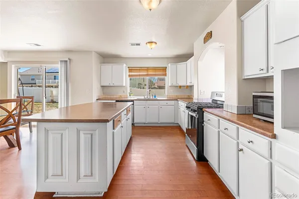 a kitchen with stainless steel appliances a sink stove and cabinets