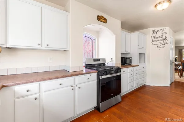 a kitchen with stainless steel appliances white cabinets and a refrigerator
