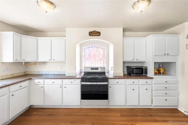 a kitchen with white cabinets and appliances