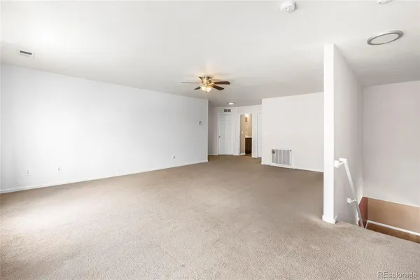 an empty room with closet and a chandelier fan