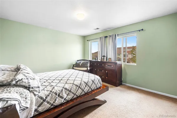 a bedroom with a bed and a potted plant on table