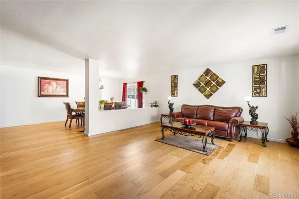 a living room with furniture and a wooden floor