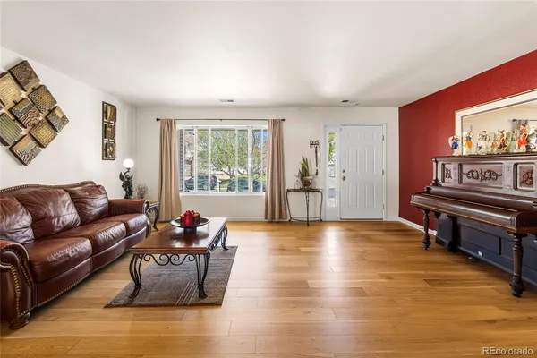 a living room with furniture and a wooden floor