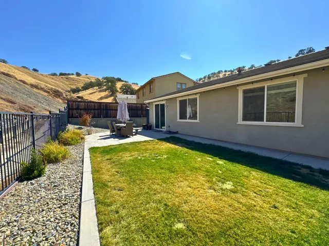 a view of a house with pool and chairs