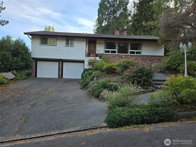 a front view of house with yard and trees around