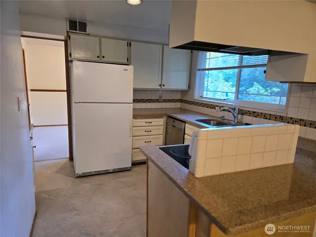 a kitchen with a stove a refrigerator and a sink