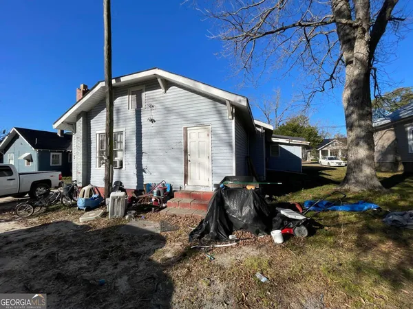 a view of a house with backyard and sitting area