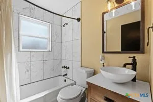 a bathroom with a sink a toilet and shower a mirror