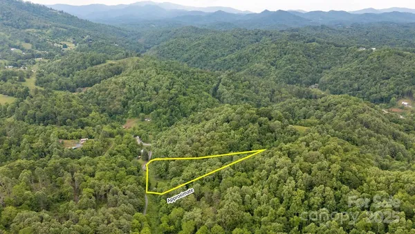 a view of a green field with mountains in the background