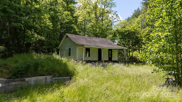 a view of a house with pool and a yard
