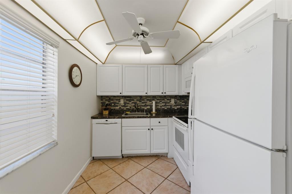 820 Flanders South, Unit 280 Delray Beach, FL 33484 - Photo 7 of 16 a kitchen with stainless steel appliances granite countertop a sink and cabinets