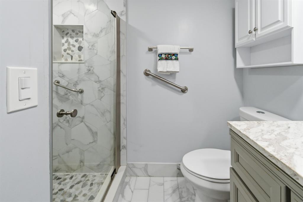 820 Flanders South, Unit 280 Delray Beach, FL 33484 - Photo 10 of 16 a bathroom with a granite countertop toilet a sink and shower