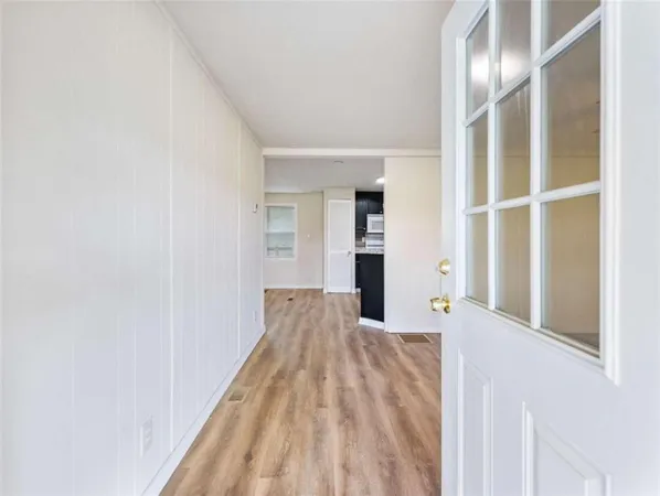 a view of empty room with wooden floor