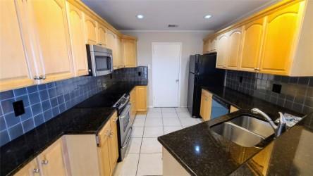 2409 Leon Street, Unit 301 Austin, TX 78705 - Photo 3 of 10 a kitchen with a sink a refrigerator and window